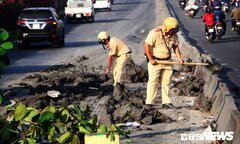 CSGT cầm cuốc xẻng dọn bùn đất rơi vãi trên quốc lộ