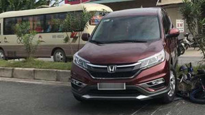 Honda CR-V lùi bất ngờ, cuốn xe máy vào gầm, leo lên dải phân cách
