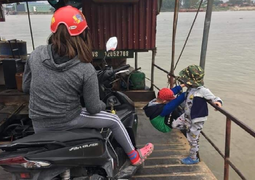 Người phụ nữ mải mê xem điện thoại bỏ mặc hai bé chơi nguy hiểm trên phà qua sông