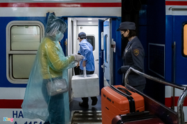 Hành khách mặc áo mưa trên chuyến tàu duy nhất còn hoạt động trong mùa dịch