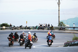 Xe máy nối đuôi vượt đèo Hải Vân vào Đà Nẵng trong khung cảnh tuyệt đẹp chiều tà