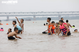 Bất chấp biển cấm, bãi cát ven sông Hồng vẫn đông người tới tắm 
