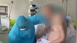 Bệnh nhân phi công người Anh ngồi dậy, đung đưa chân trên giường bệnh 