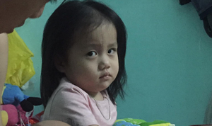 Vẻ mặt hờn dỗi của bé gái khi bố mải bế em