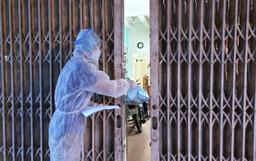 Cán bộ y tế đội mưa đưa cơm vào khu cách ly COVID-19 ở Đắk Lắk