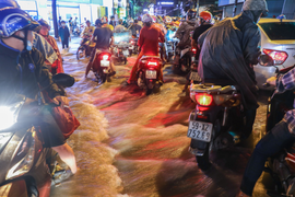 Nước đổ cuồn cuộn, xe máy chao đảo sau mưa lớn ở TP.HCM