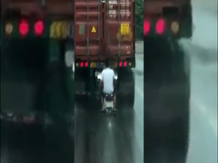 Clip: Người đàn ông đi xe máy cố tình bám đuôi container để tránh mưa