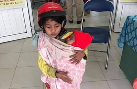 Nghẹn ngào hình ảnh chị 7 tuổi địu em 5 tháng tuổi đi tiêm chủng 