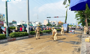 Ảnh: CSGT TP.HCM đội nắng gắt dọn đường, rải cát giúp dân đi không bị trượt ngã