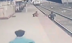 Video: Giải cứu em bé trước mũi tàu hỏa trong gang tấc