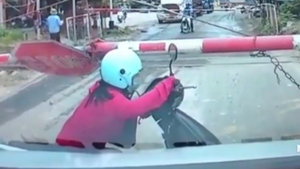 Video: Bất chấp nguy hiểm, người phụ nữ chui qua barie vượt qua đường ray