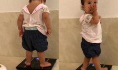 Biểu cảm hài hước của bé gái khi đứng lên cân