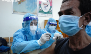 Ảnh: Người TP.HCM đội mưa đi tiêm vaccine Sinopharm trong đêm