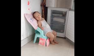 Trời nóng, em bé mở cửa tủ lạnh để ngủ 