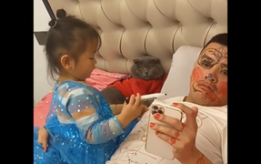 Ông bố cam chịu nằm yên cho con gái vẽ đầy mặt