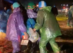 Đoàn người hồi hương hì hục đẩy xe qua đoạn đường ngập nước lúc nửa đêm