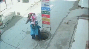 Video: Mải nghe điện thoại, người mẹ bế con nhỏ hụt chân rơi xuống cống