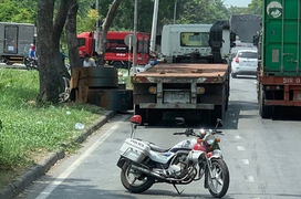 Cuộn thép trên xe đầu kéo rơi xuống đường, đụng trúng người bán vé số