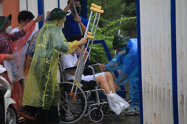 Thí sinh ngồi xe lăn đội mưa đi thi tốt nghiệp THPT