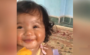 Bé gái cười tít mắt khi được ăn xoài