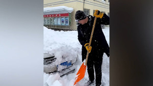 Tài xế đào tuyết tìm ô tô ở Trung Quốc