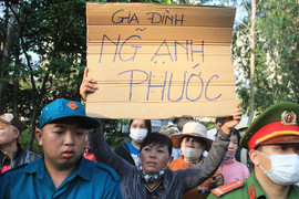 Người mẹ giơ cao tấm biển ghi tên con trai trong lễ giao nhận quân ở TP.HCM