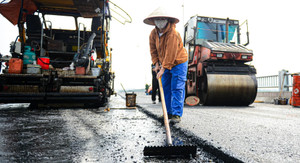 Công nhân đội nắng trải thảm nhựa trên công trường cầu Vĩnh Tuy giai đoạn 2