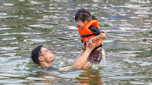 Trời nắng, phụ huynh đưa con nhỏ ra bơi ở ao làng