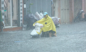 Mưa trắng trời, người dân Hà Nội chật vật ‘bơi qua biển nước’