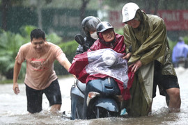 Người Hà Nội 'bơi' trên phố, hì hục tát nước khỏi nhà sau trận mưa như trút