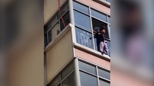 Người đàn ông đu dây cứu cậu bé mắc kẹt ở cửa sổ