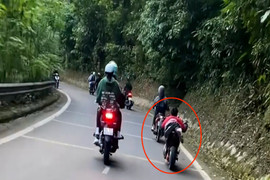 Nam thanh niên nằm trên yên xe máy điện, lao vun vút trên đường đèo