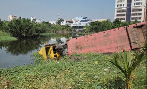 Xe container chở cuộn thép 20 tấn lao xuống hồ nước ven đường ở TP.HCM