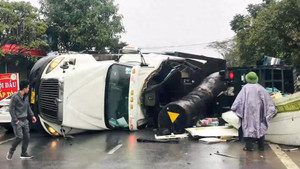 Khoảnh khắc xe đầu kéo chở 26 tấn gỗ lật nhào vào xe tải