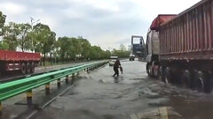 Tài xế dừng xe tải bắt cá trên đường cao tốc ngập nước 