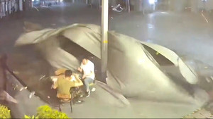 Gió mạnh hất tung tấm bạt, 2 người đàn ông ngã nhào