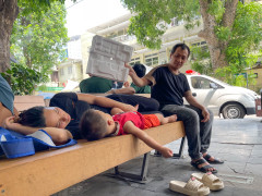 Ông bố ngồi dưới gốc cây ở bệnh viện, chăm con trai ngủ giữa ngày nắng đỉnh điểm