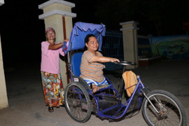 Cảm động hình ảnh người mẹ già đẩy xe lăn cùng con khuyết tật đi học