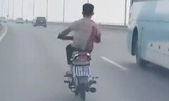 Nam thanh niên đầu trần đi xe máy biển xanh, đánh võng trên cầu Nhật Tân