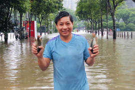 Người Hà Nội bắt cá giữa đường, 'đắp đê' chắn nước trước hầm xe