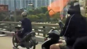 Thanh niên chạy xe máy dùng điện thoại ở Hà Nội...