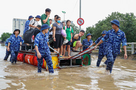 Nhiều tuyến đường ở Hà Nội vẫn ngập sâu, bộ đội chia ca túc trực dìu dân qua điểm nguy hiểm
