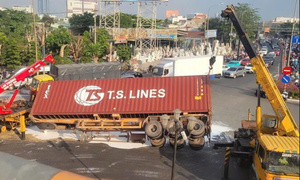 Xe container lật giữa vòng xoay ở TP.HCM, sơn trắng tràn mặt đường