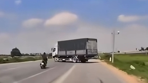 Video: Thanh niên chạy xe máy trượt ngã vào gầm ô tô tải đang quay đầu