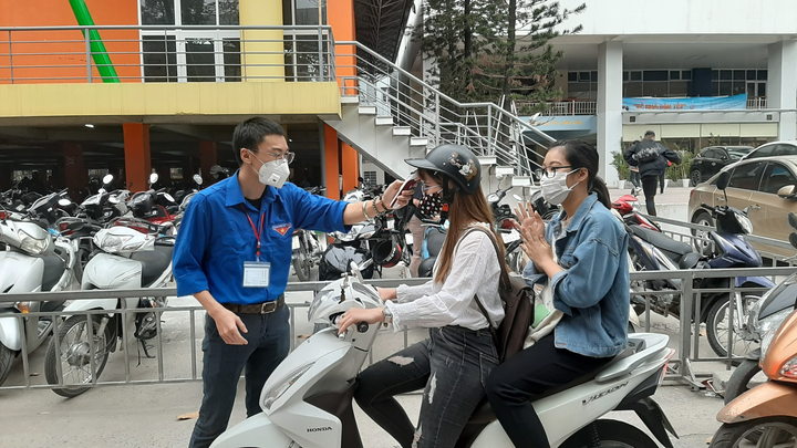 Sinh viên xếp hàng đo thân nhiệt ngày đầu quay lại trường sau kỳ nghỉ vì Covid-19 - 1