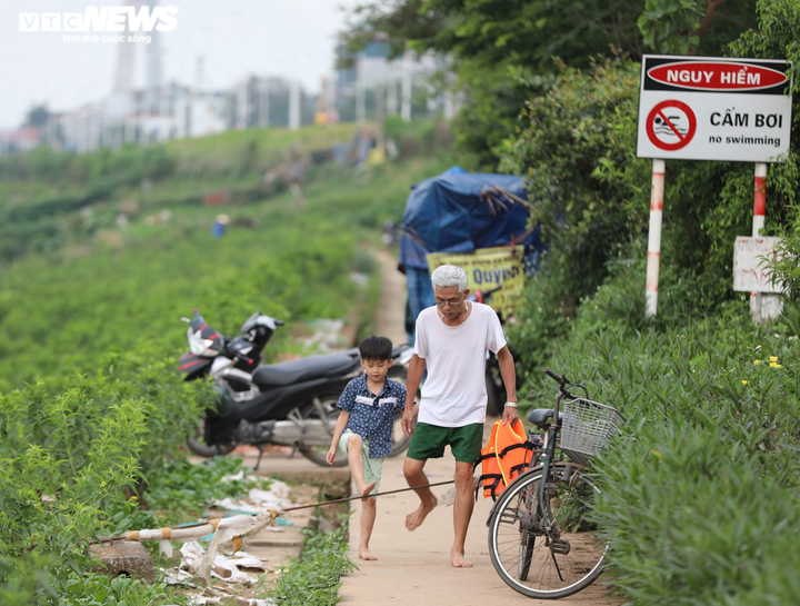 Bất chấp biển cấm, bãi cát ven sông Hồng vẫn đông người tới tắm - 1