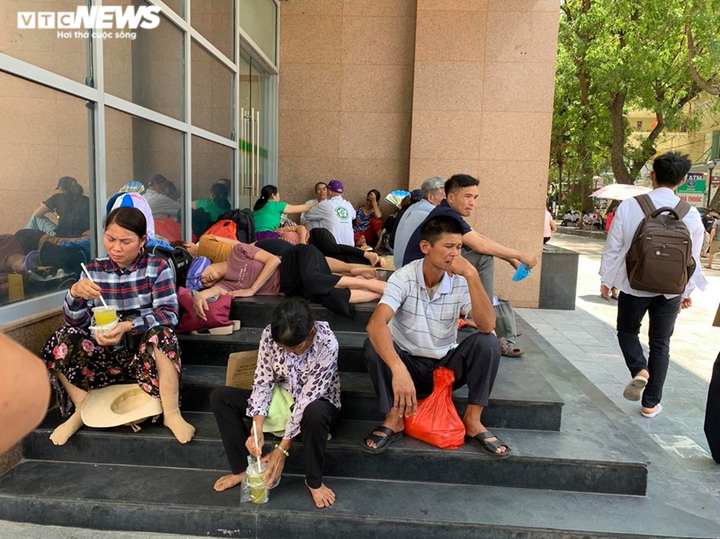 Người nhà bệnh nhân ăn cơm dưới chân tòa nhà, ngủ ở gốc cây trốn nắng nóng - 3