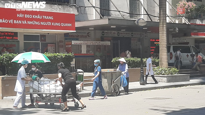 Người nhà bệnh nhân ăn cơm dưới chân tòa nhà, ngủ ở gốc cây trốn nắng nóng - 13