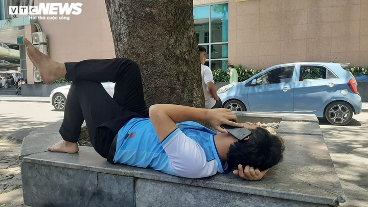 Người nhà bệnh nhân ăn cơm dưới chân tòa nhà, ngủ ở gốc cây trốn nắng nóng - 10