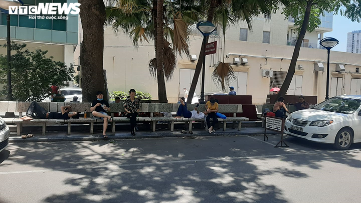 Người nhà bệnh nhân ăn cơm dưới chân tòa nhà, ngủ ở gốc cây trốn nắng nóng - 9